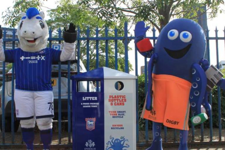 Mascots Bluey and DiGBY standing next to one of the new Ipswich Borough Council bins