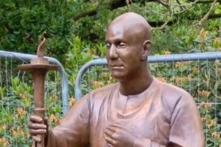 A lifesize bronze sculpture of a man in traditional Indian outfit