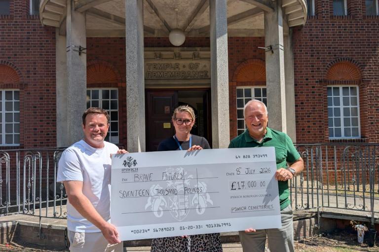 Three people holding a large cheque for £17,000