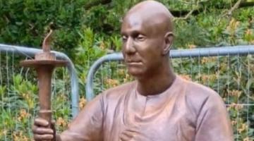A lifesize bronze sculpture of a man in traditional Indian outfit